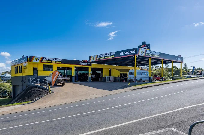 All Coast Tyres Dunlop Super Dealer store front in Gympie, Queensland, with yellow and black signage on a sunny day.