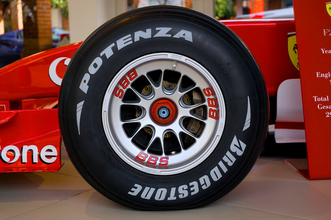 Close-up of a Formula One racing car wheel with white Bridgestone Potenza tyre lettering.
